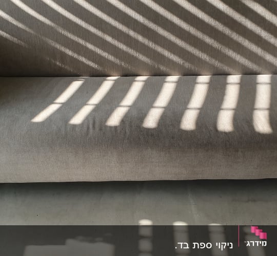 ספה אפורה עם צללים של תריסים